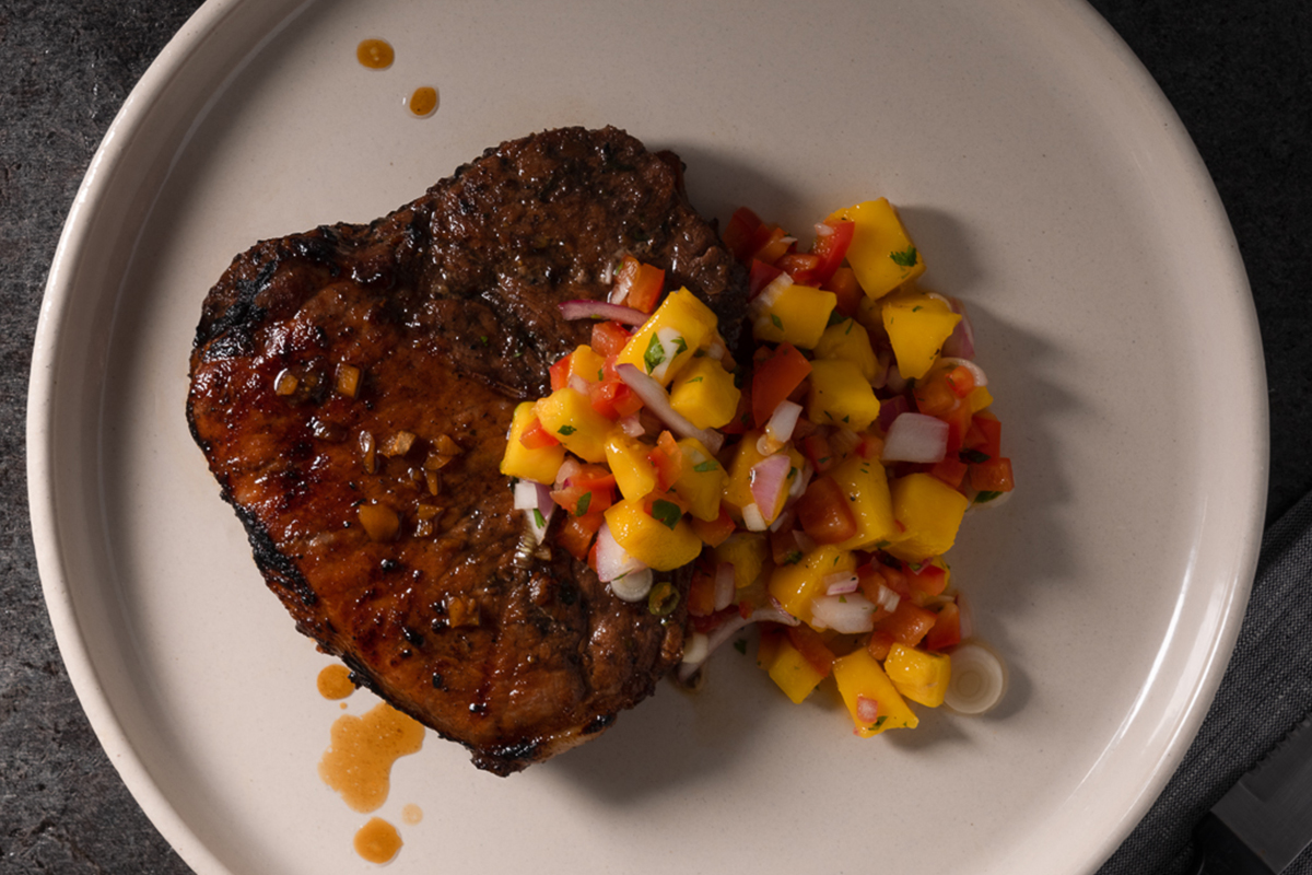 Grilled jerk pork chop glazed with aged rum and topped with mango relish | Prairie Fresh®