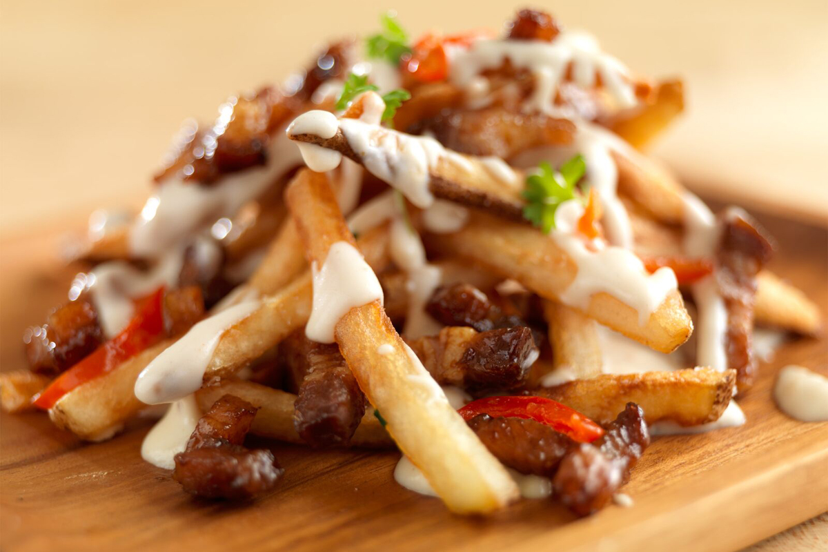 Crispy pork belly fries drizzled with sauce | Prairie Fresh®